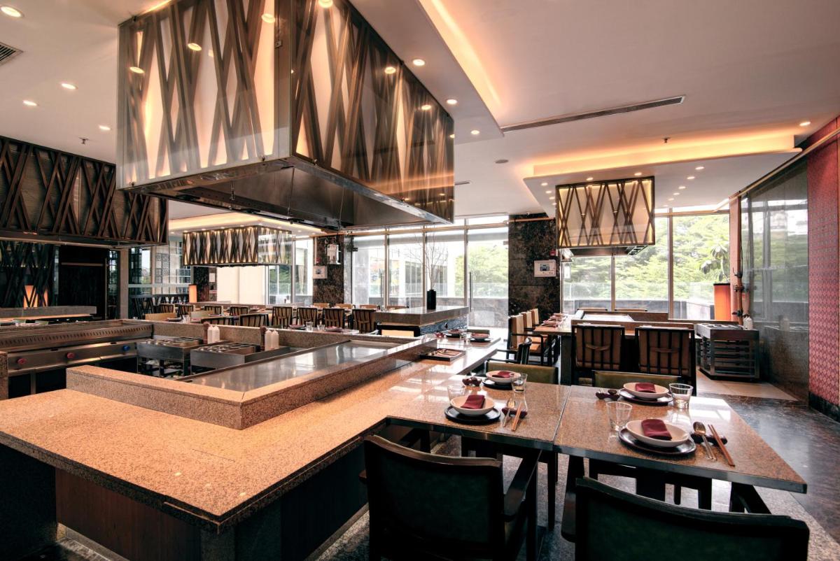 a restaurant with tables and chairs in a room at Hyatt Ahmedabad in Ahmedabad