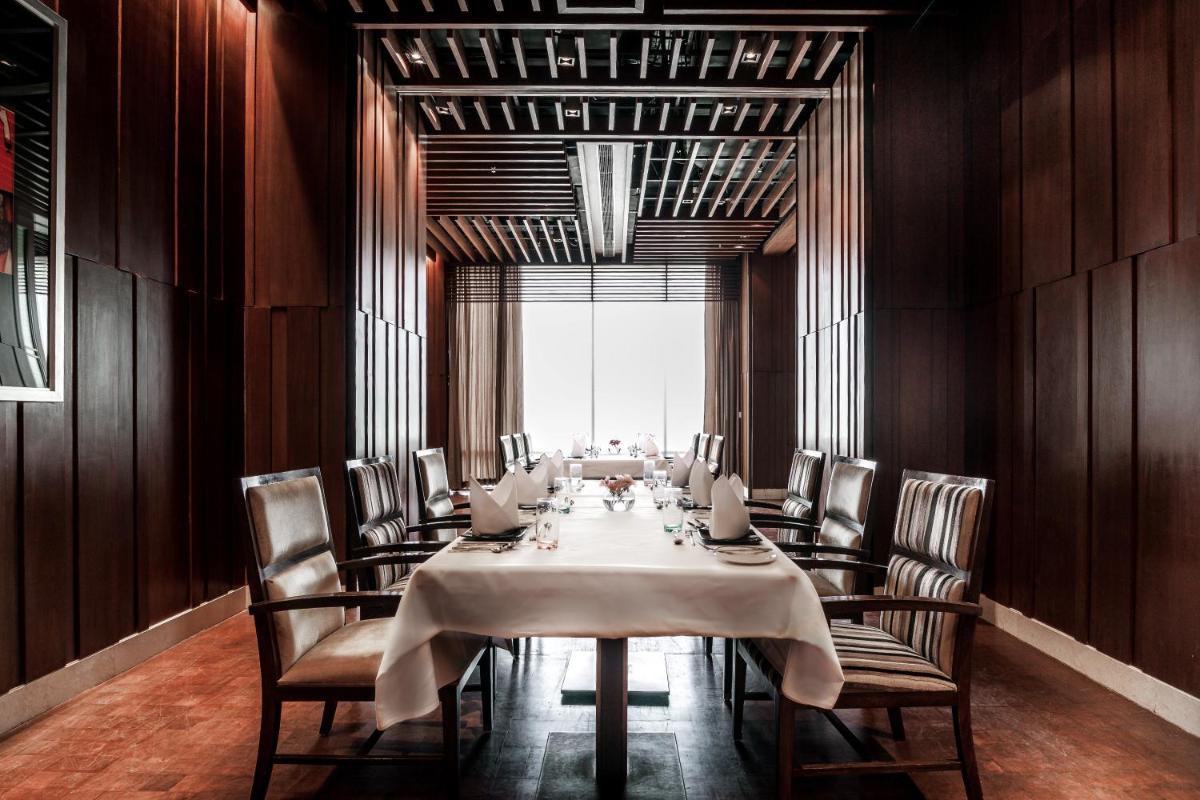 a long dining room with a table and chairs at Hyatt Ahmedabad in Ahmedabad