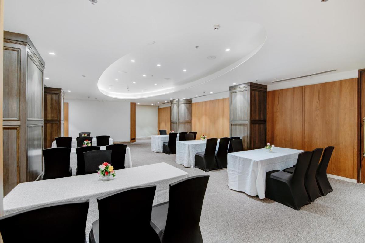 a conference room with white tables and black chairs at Hyatt Ahmedabad in Ahmedabad