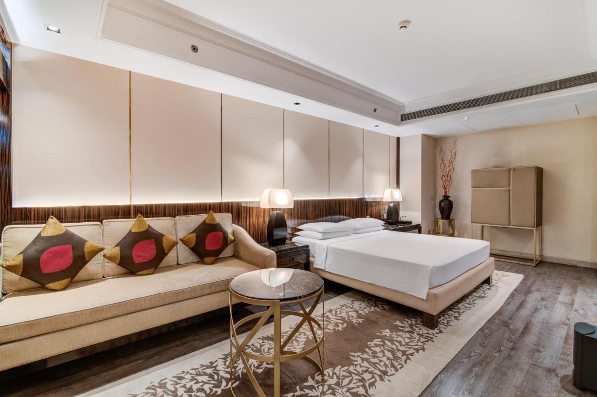 a hotel room with a bed and a couch at Hyatt Ahmedabad in Ahmedabad