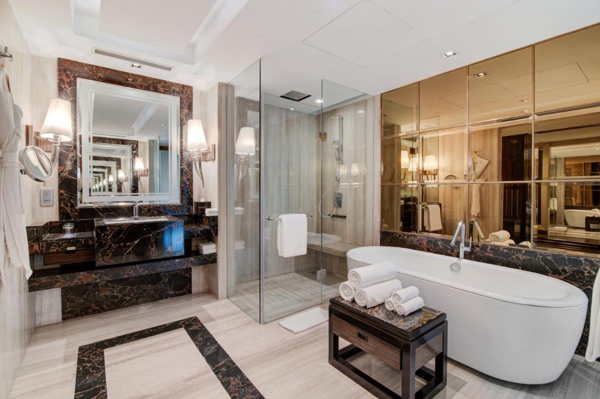 a bathroom with a tub and a glass shower at Hyatt Ahmedabad in Ahmedabad