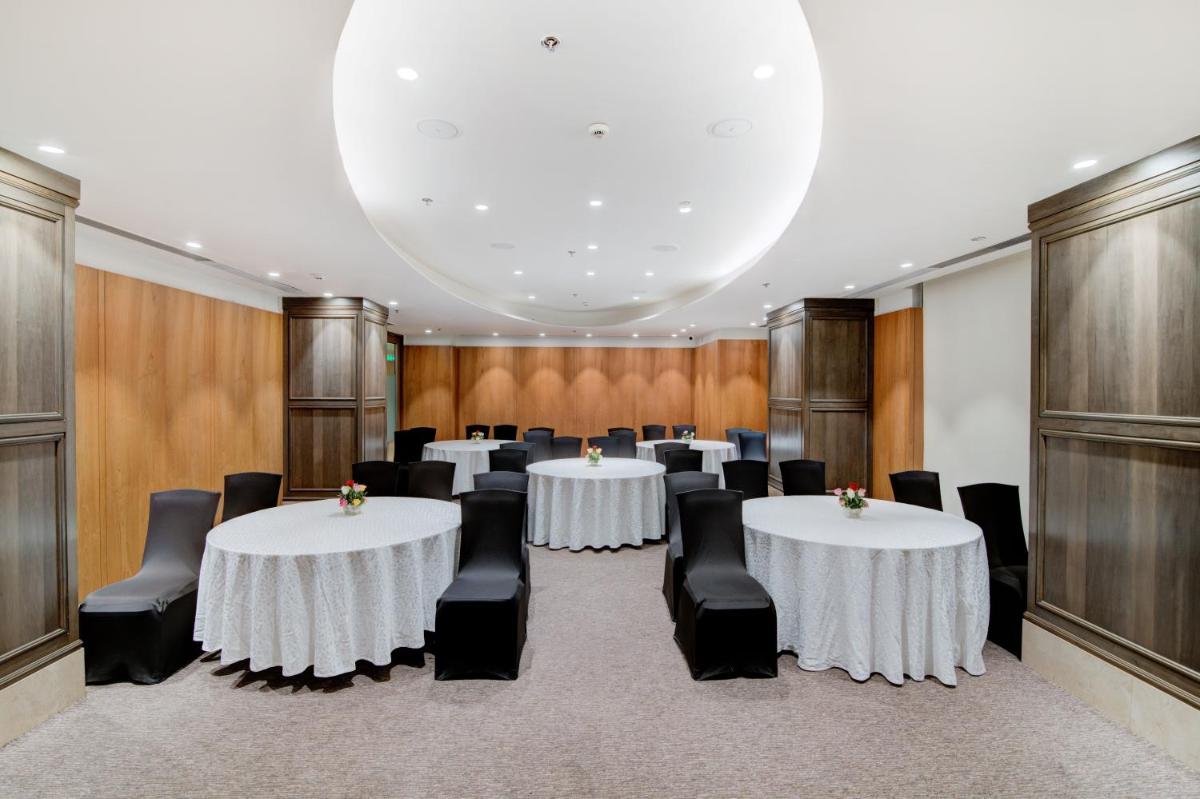 a conference room with white tables and black chairs at Hyatt Ahmedabad in Ahmedabad