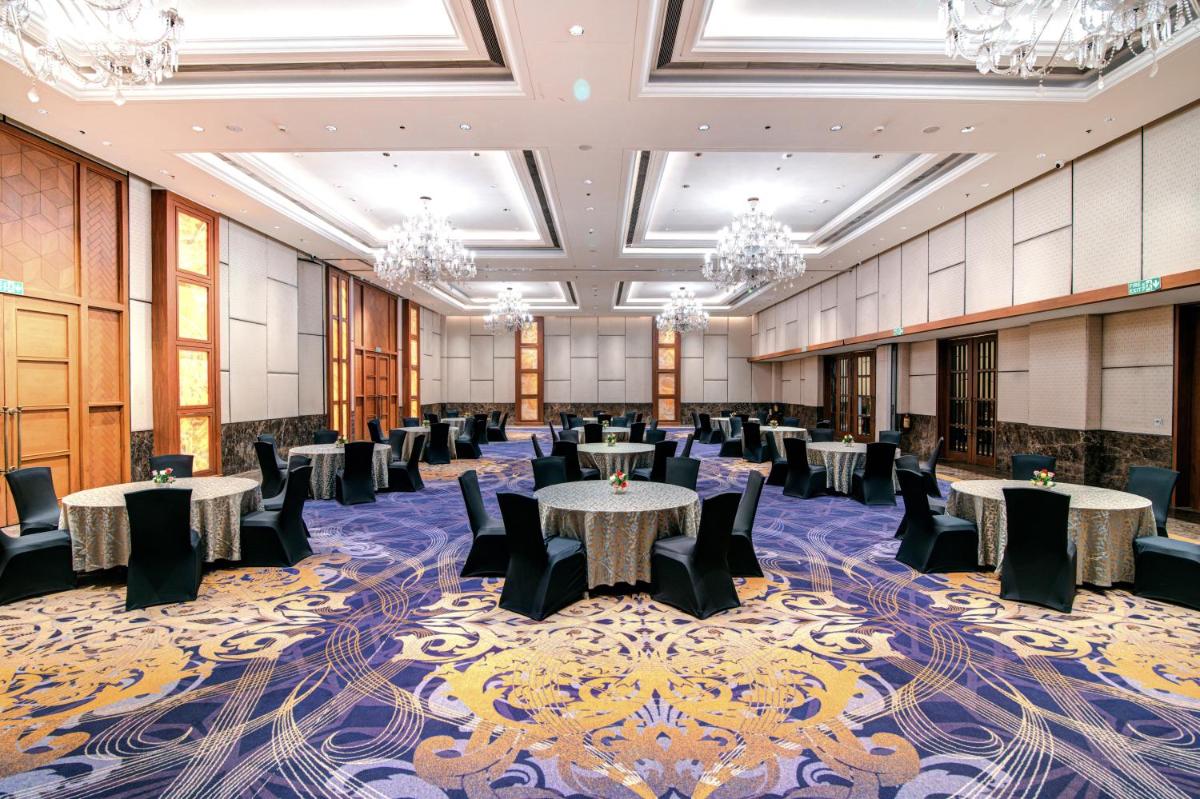 a banquet hall with tables and chairs and chandeliers at Hyatt Ahmedabad in Ahmedabad