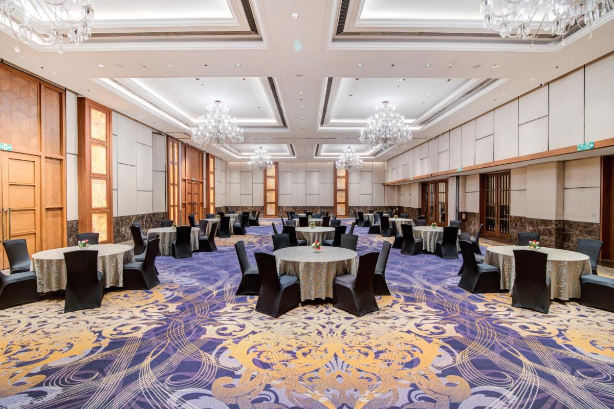 a banquet hall with tables and chairs and chandeliers at Hyatt Ahmedabad in Ahmedabad