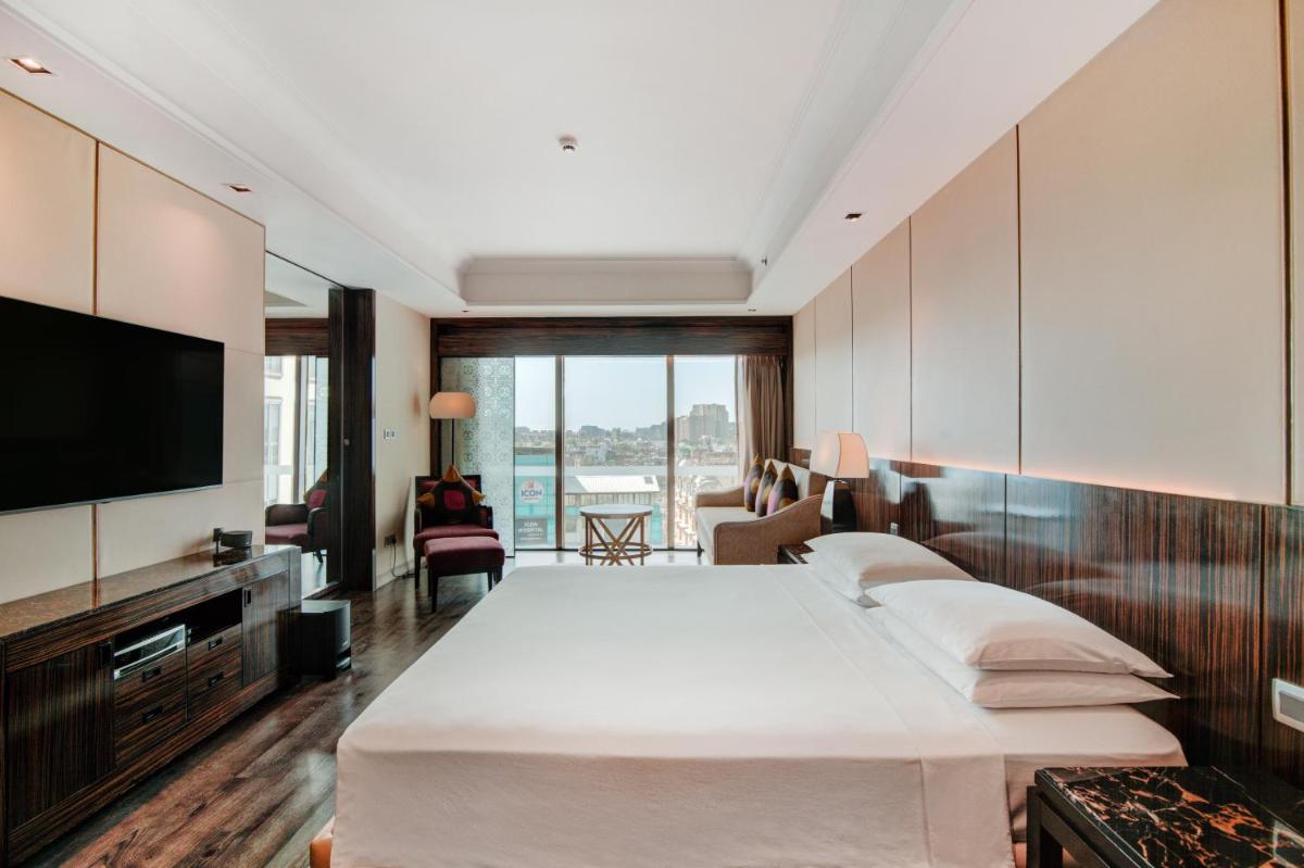 a hotel room with a bed and a flat screen tv at Hyatt Ahmedabad in Ahmedabad