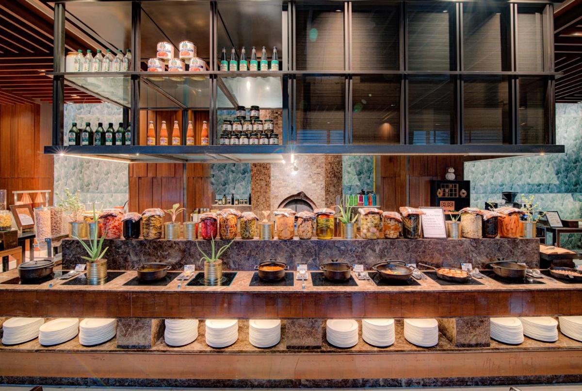 a restaurant with a counter with food and drinks at Hyatt Ahmedabad in Ahmedabad