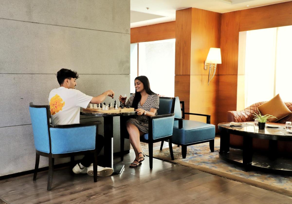 a man and woman sitting at a table in a restaurant at Hyatt Ahmedabad in Ahmedabad