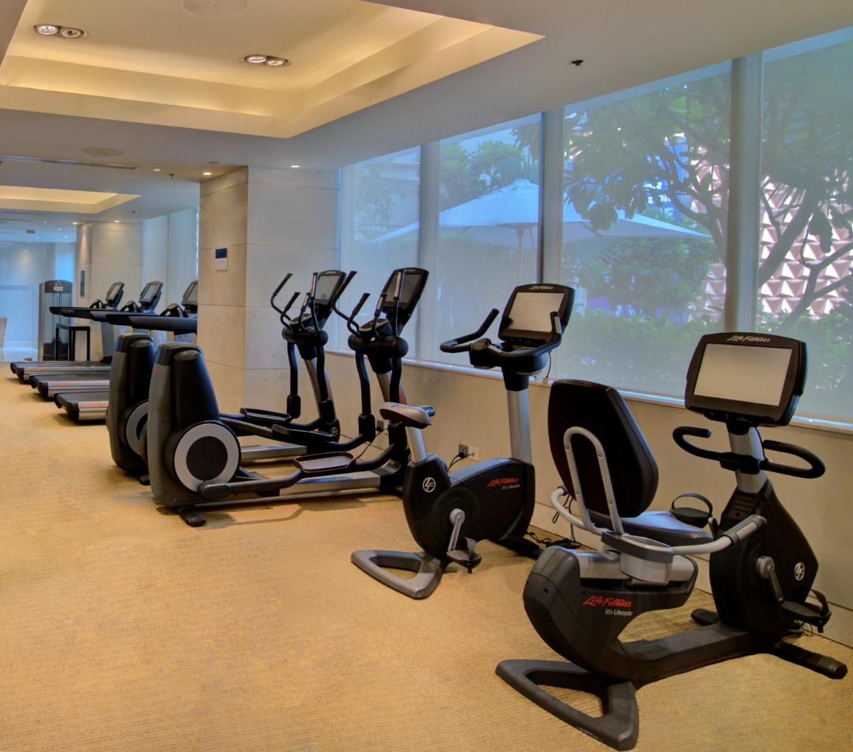 a gym with a row of exercise bikes and ellipticals at Hyatt Ahmedabad in Ahmedabad