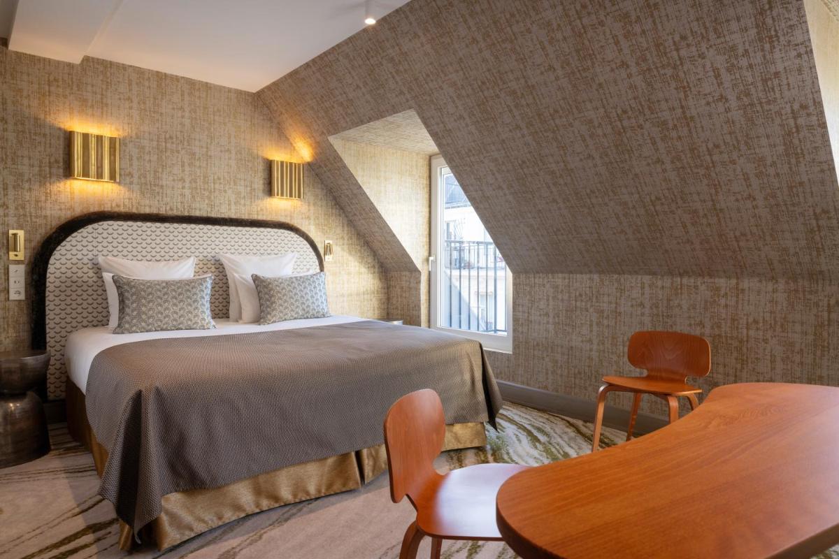 une chambre d'hôtel avec un lit et une table dans l'établissement Hotel des Carmes by Malone, à Paris 97 autres photos