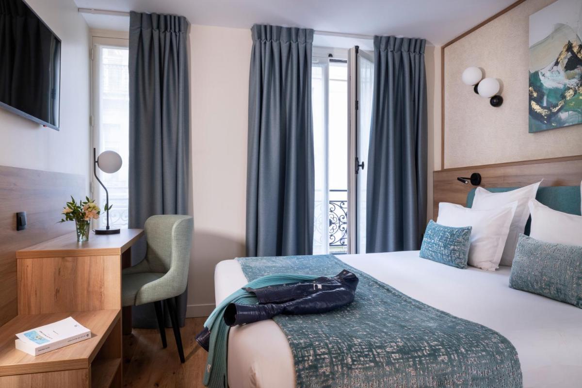 une chambre d'hôtel avec un lit et un bureau dans l'établissement Hôtel Théorème, à Paris