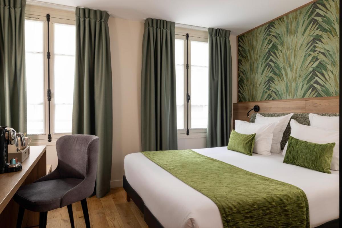 une chambre d'hôtel avec un lit et une chaise dans l'établissement Hôtel Théorème, à Paris