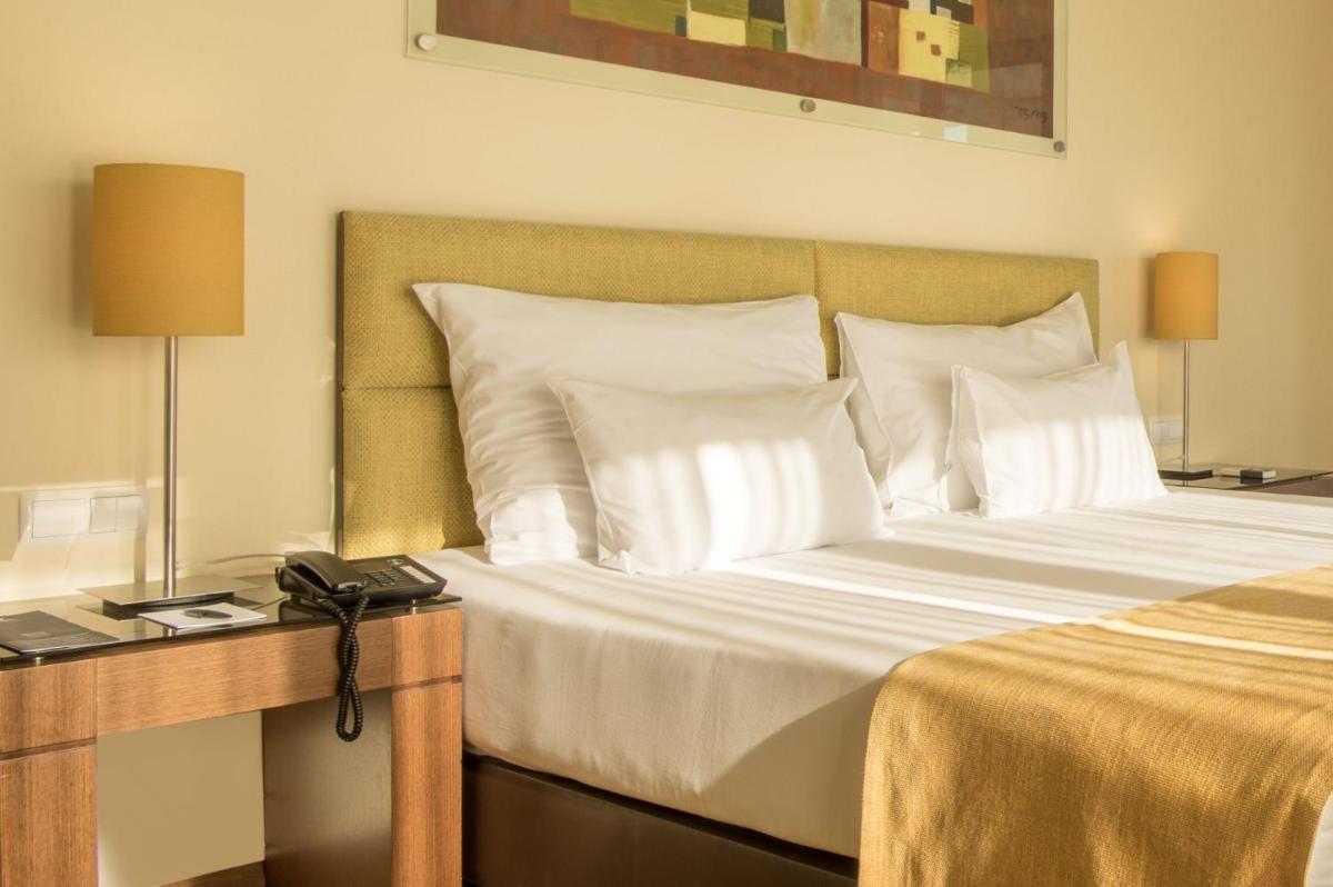 Uma cama ou camas num quarto em Vila Gale Coimbra