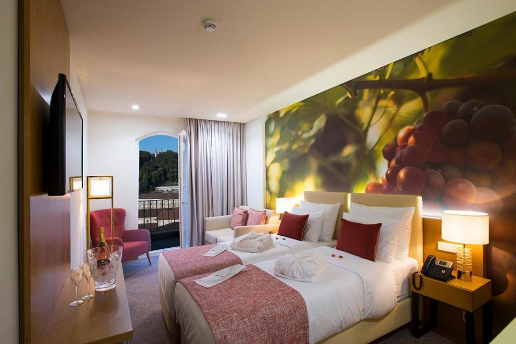 um quarto de hotel com uma cama com um quadro na parede em Douro Castelo Signature Hotel & Spa em Lamego