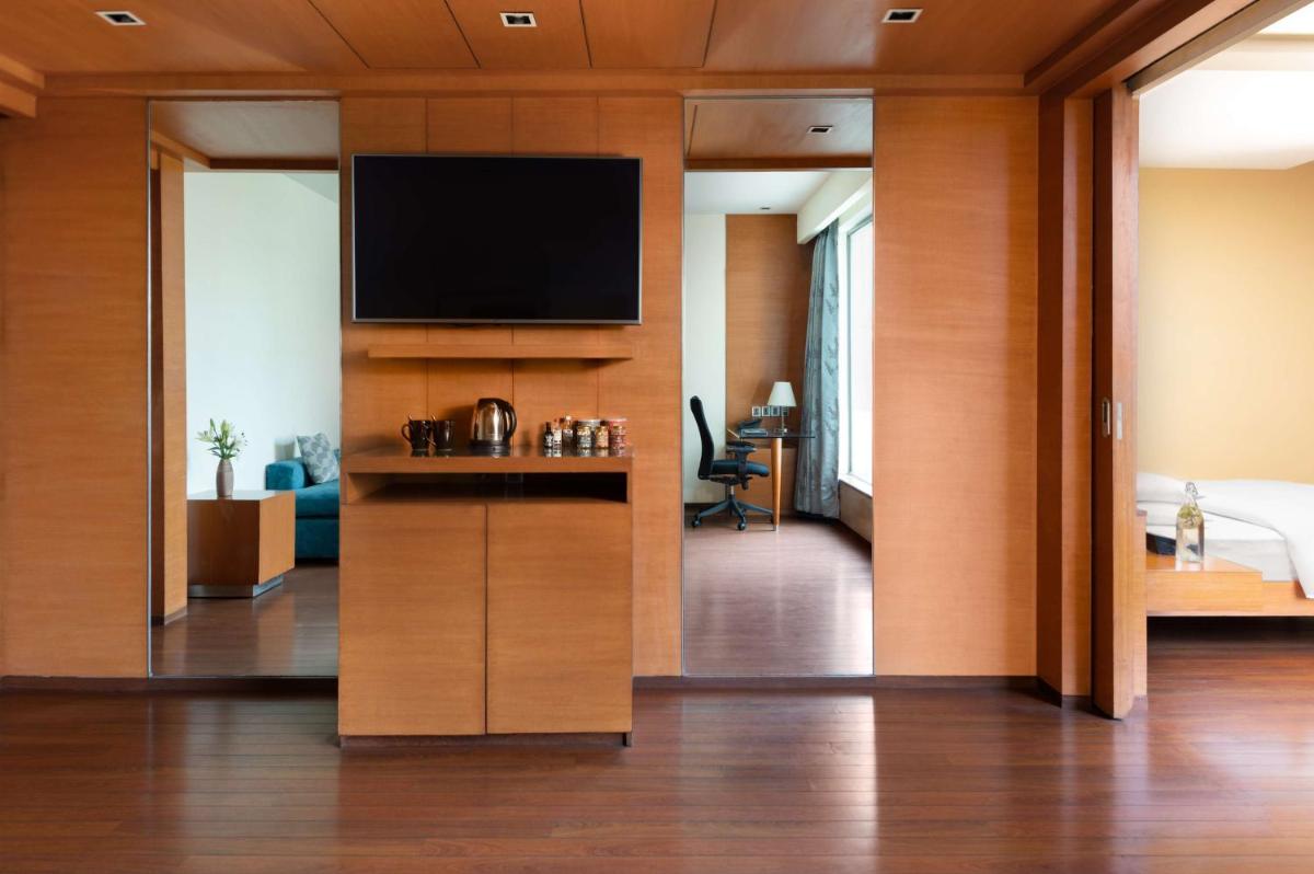 a hotel room with a flat screen tv on a wall at Hyatt Pune in Pune