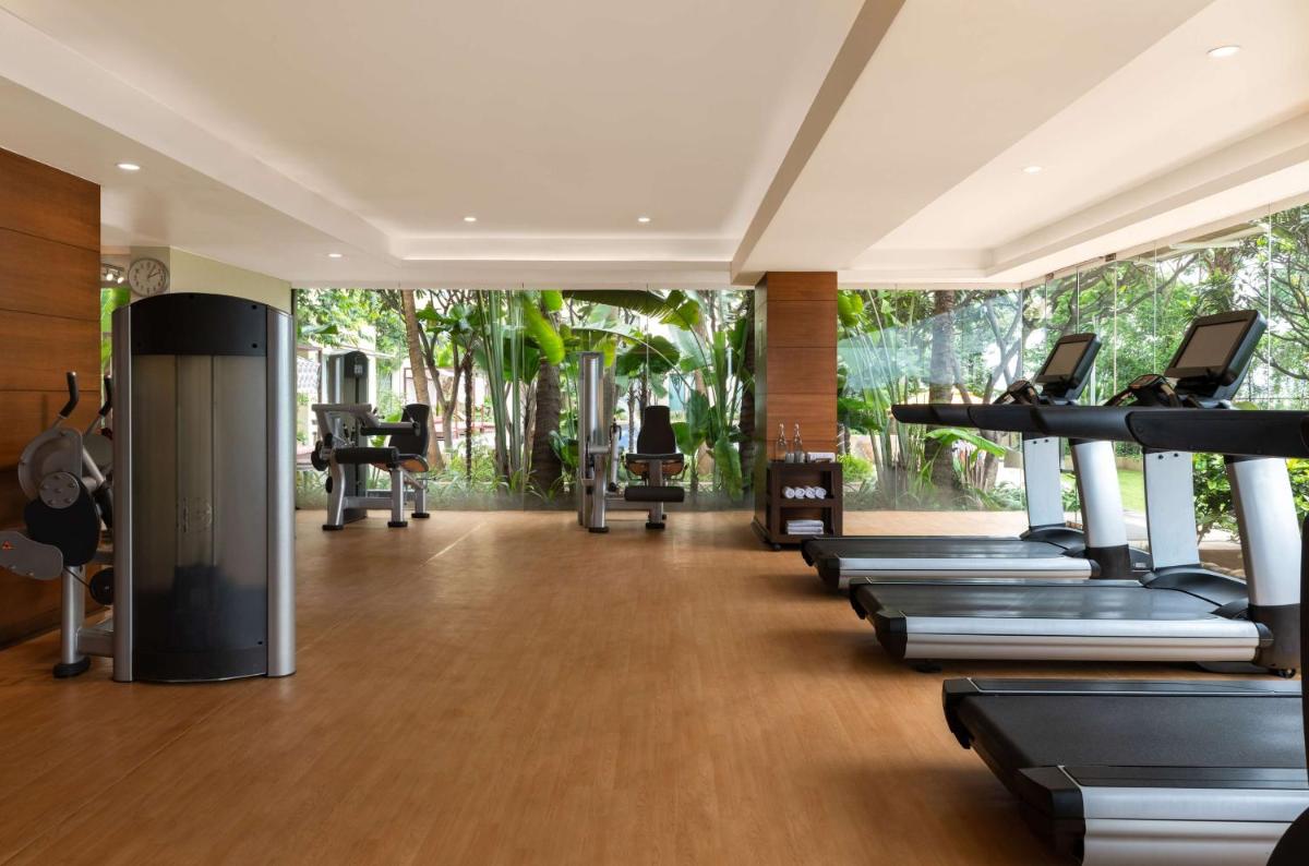 a gym with a row of treadmills and machines at Hyatt Pune in Pune