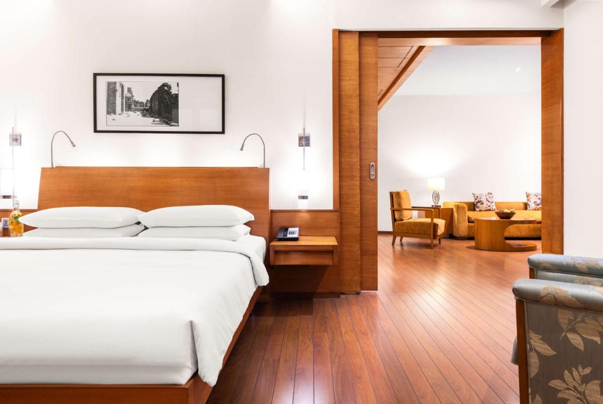 a bedroom with a bed and a living room at Hyatt Pune in Pune