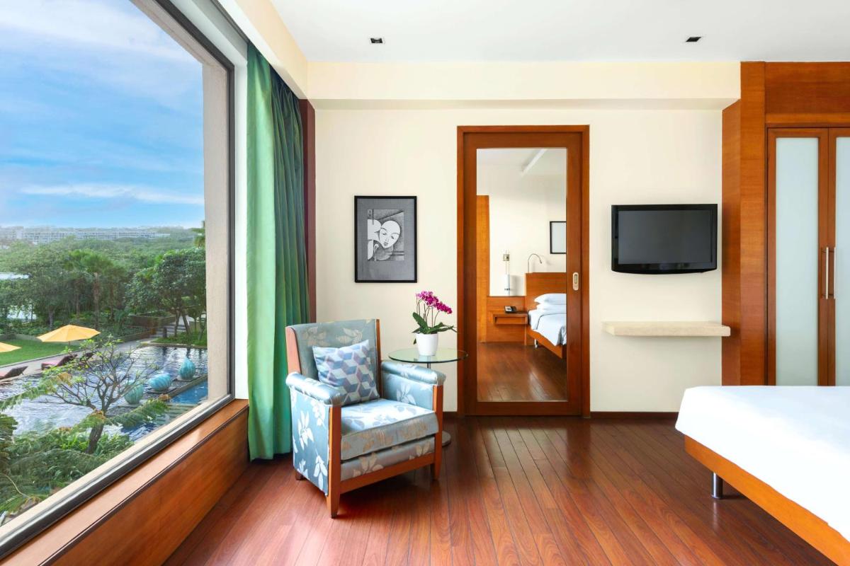 a bedroom with a bed and a large window at Hyatt Pune in Pune