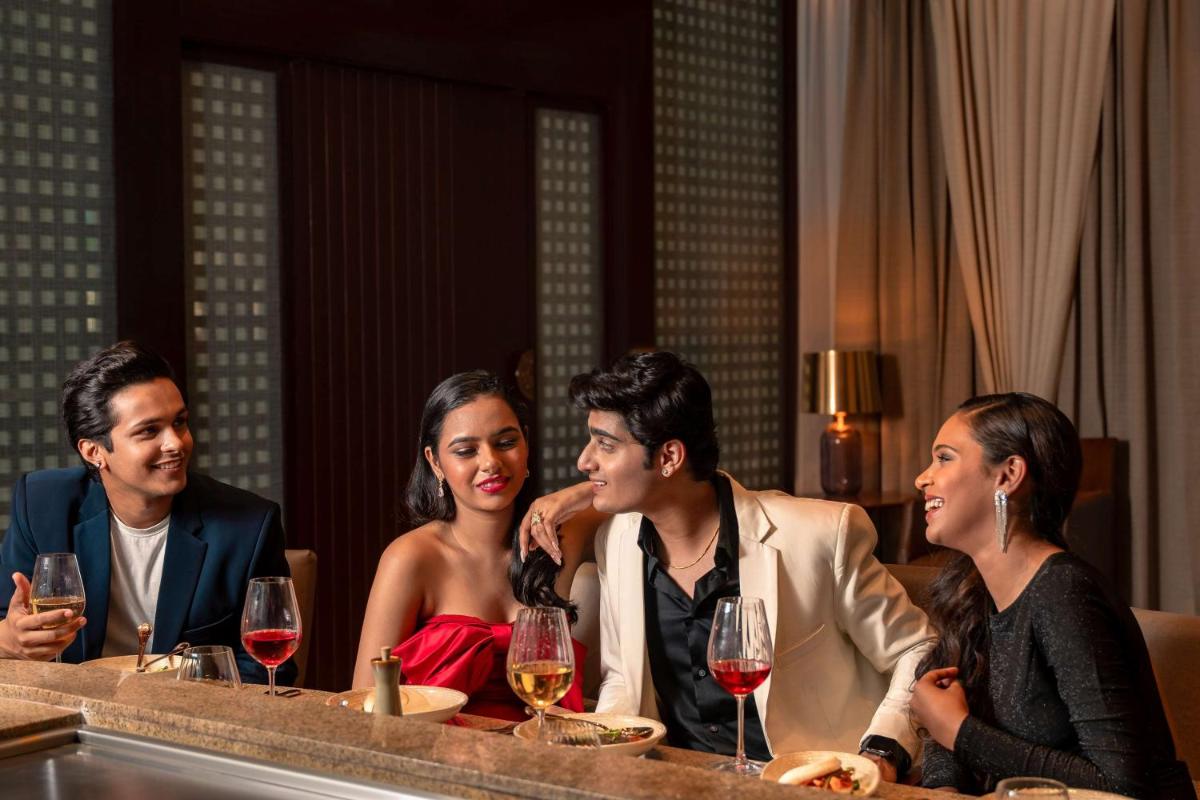 a group of people sitting at a table with wine glasses at Hyatt Pune in Pune