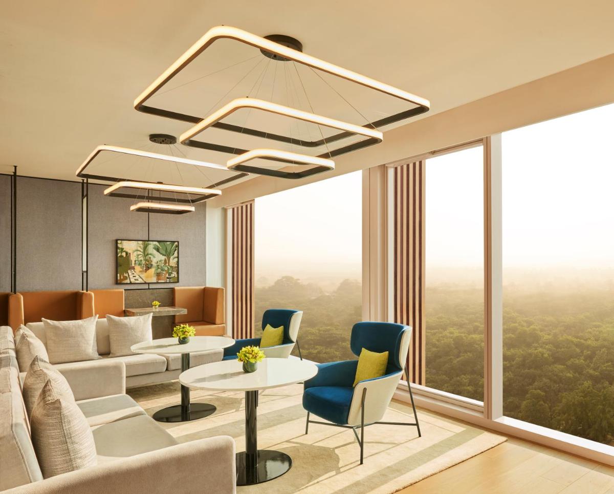 a living room with a couch and a table and chairs at Taj The Trees, Mumbai in Mumbai