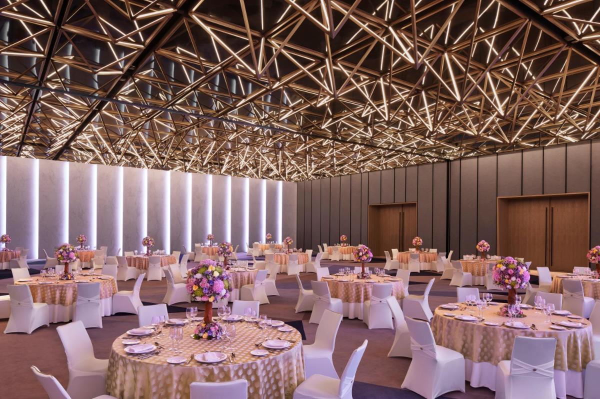 a banquet hall with white tables and white chairs at Taj The Trees, Mumbai in Mumbai +34 photos