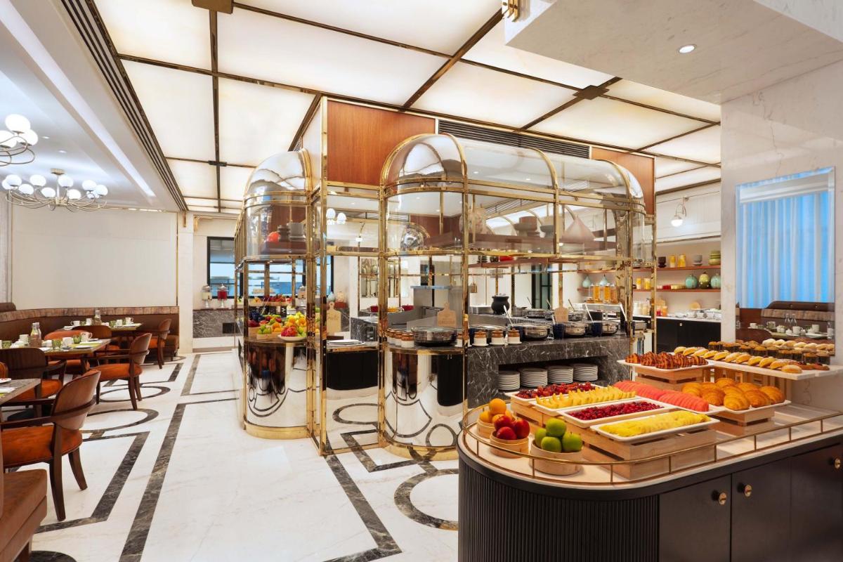 a restaurant with a bunch of food on display at ITC Narmada, a Luxury Collection Hotel, Ahmedabad in Ahmedabad