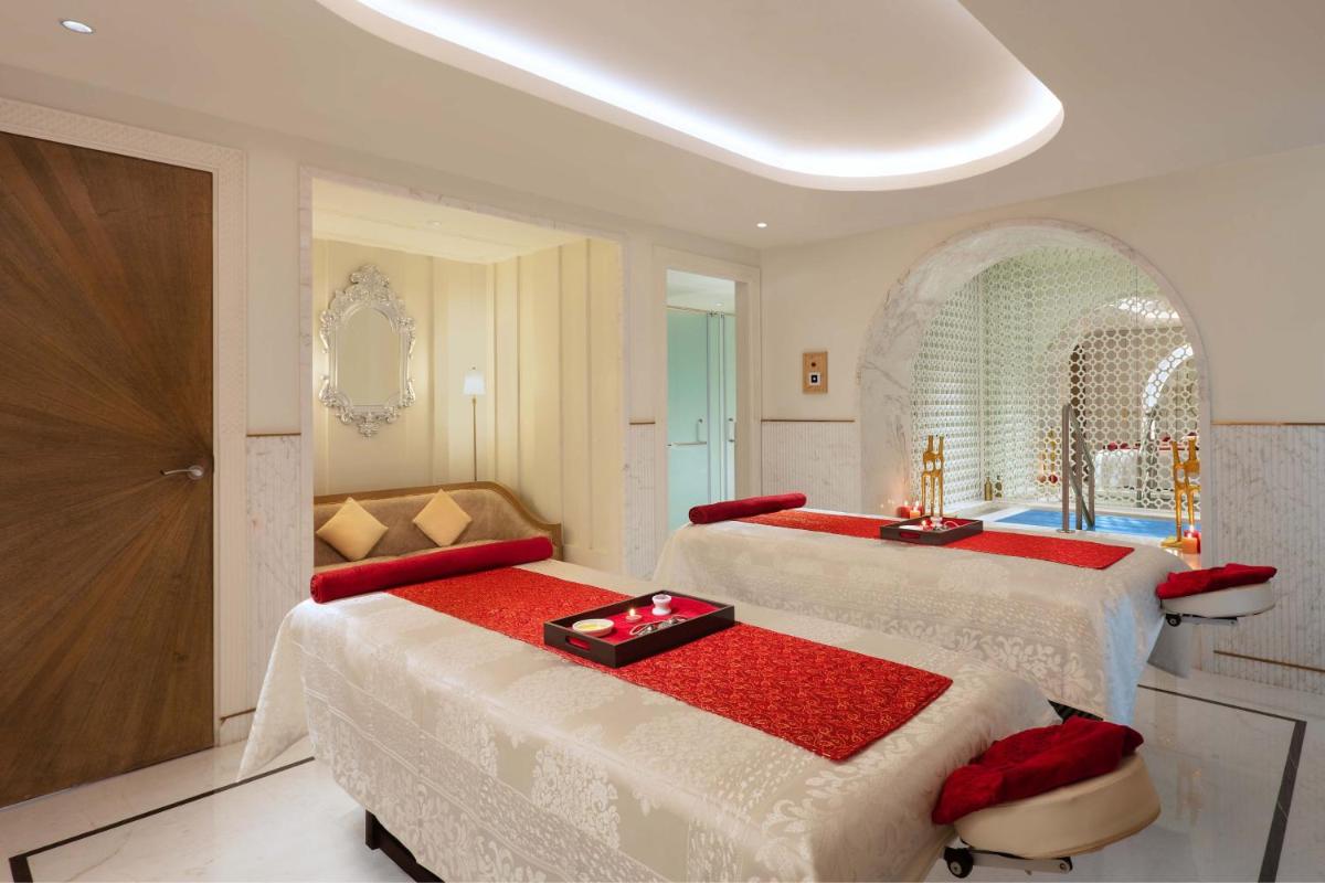 a bedroom with two beds with red and white covers at ITC Narmada, a Luxury Collection Hotel, Ahmedabad in Ahmedabad