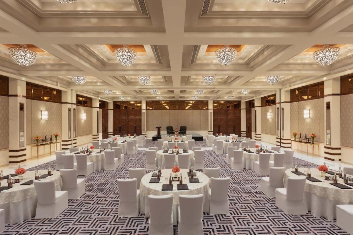 a large banquet hall with white tables and chairs at ITC Narmada, a Luxury Collection Hotel, Ahmedabad in Ahmedabad +70 photos