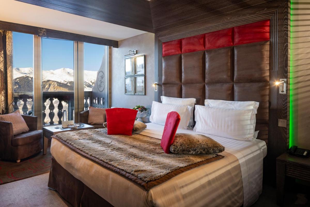 - une chambre avec un grand lit et une vue sur la montagne dans l'établissement Le Lana, à Courchevel 37 autres photos