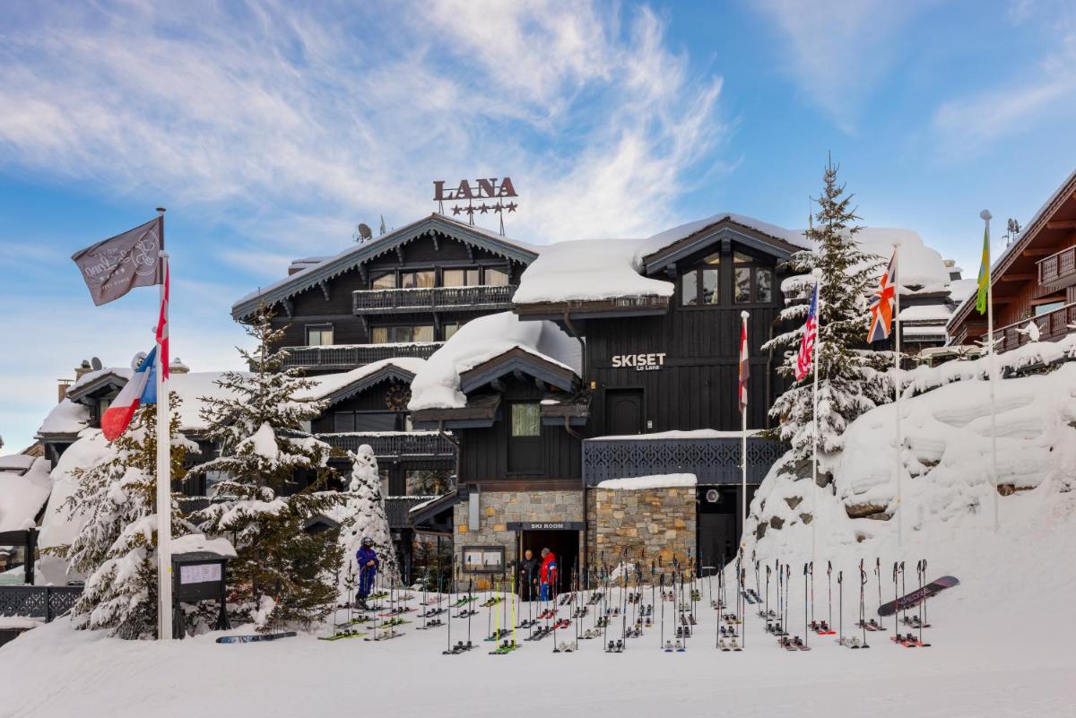 un lodge de ski avec un tas de skis dans la neige dans l'établissement Le Lana, à Courchevel