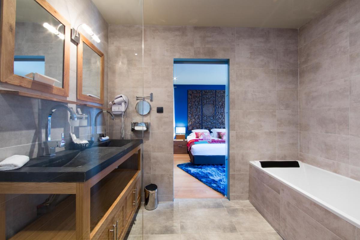 La salle de bains est pourvue d'un lavabo et d'une baignoire. dans l'établissement Domaine de Chalvêches Hôtel SPA 4*, à Faugères
