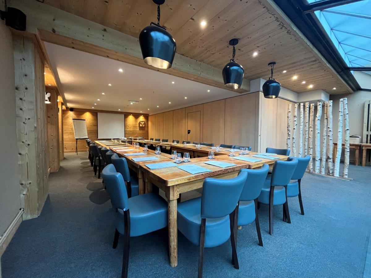 une grande salle de conférence avec une longue table et des chaises dans l'établissement Hôtel et Spa les Clarines, à Corrençon-en-Vercors