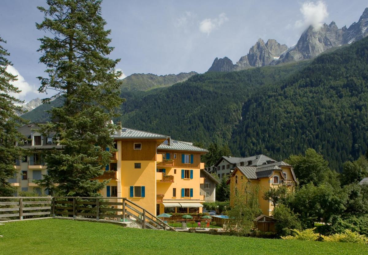 un groupe de bâtiments avec des montagnes en arrière-plan dans l'établissement Hôtel Lyret, à Chamonix-Mont-Blanc