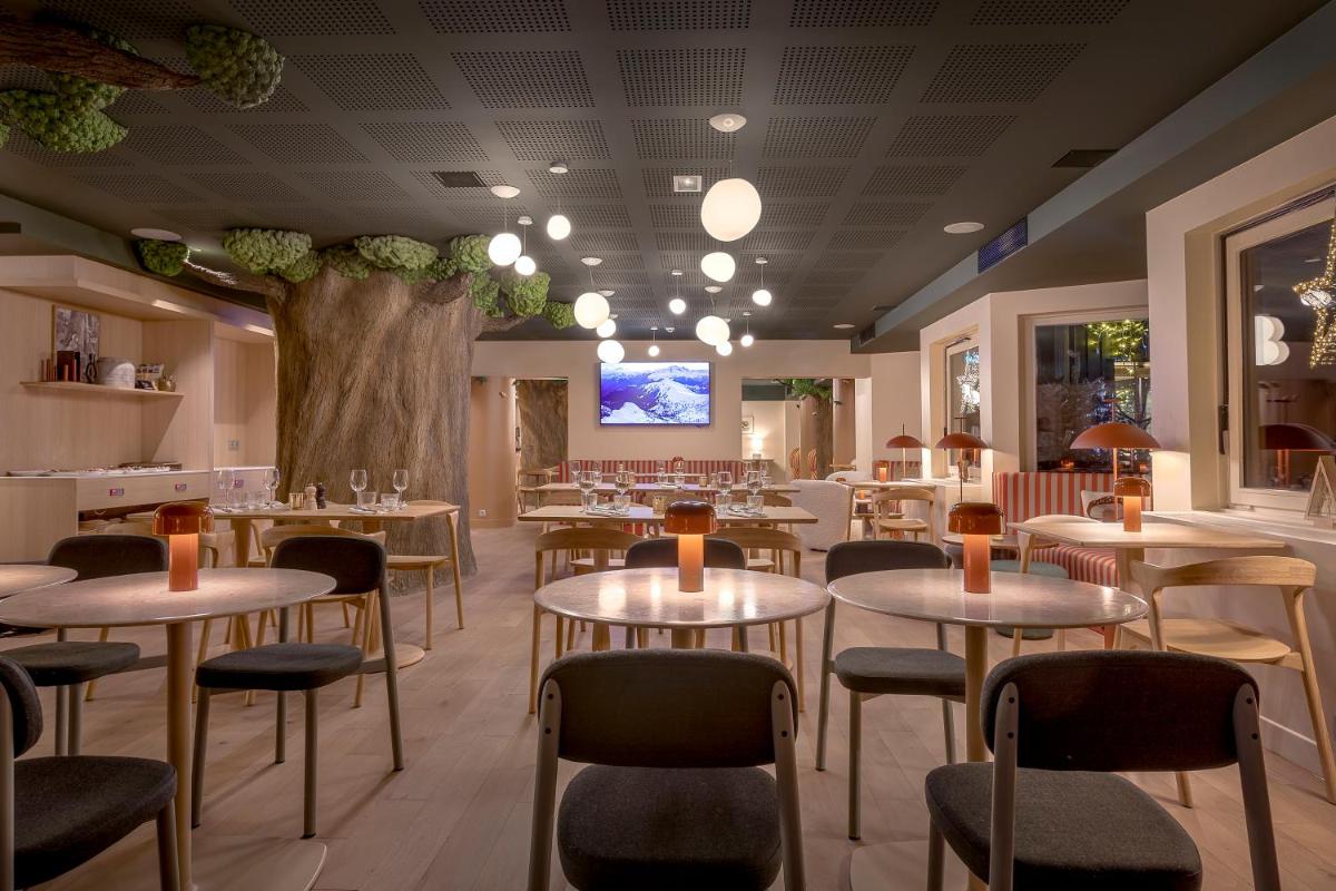 un restaurant avec des tables, des chaises et un arbre dans l'établissement Lykke Hôtel & Spa Chamonix - ex Mercure, à Chamonix-Mont-Blanc