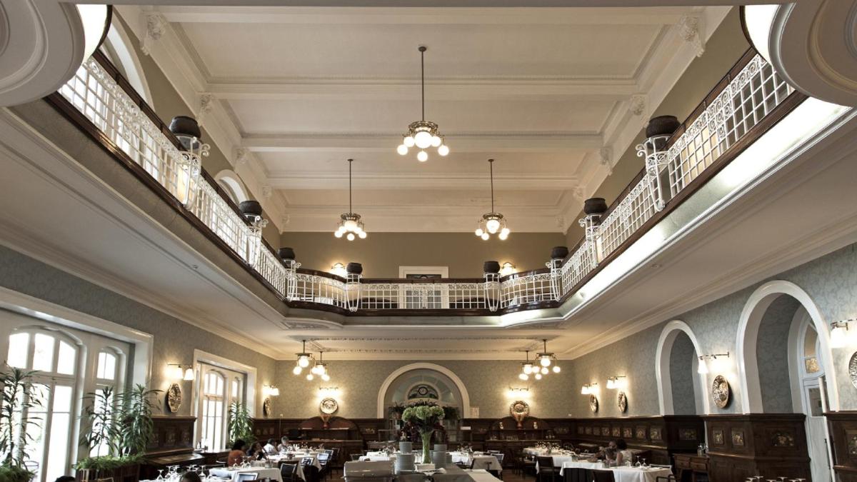 uma sala de jantar com mesas e lustres em Curia Palace Hotel & Spa em Curia