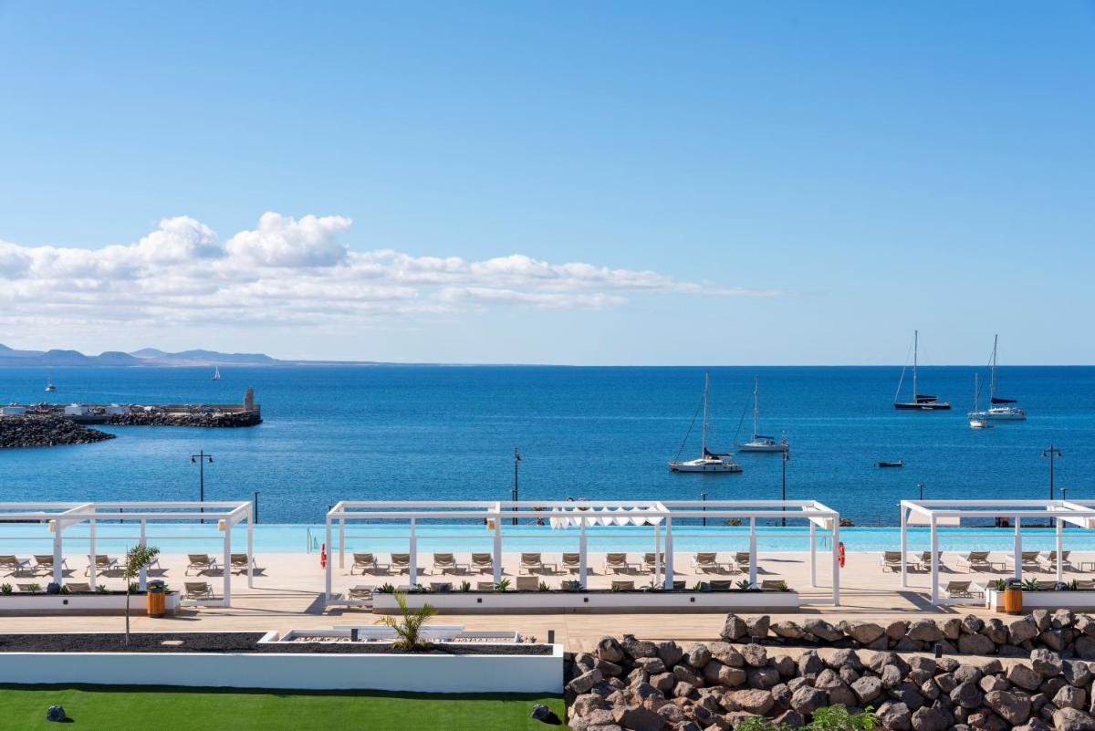 Una vista de una playa con barcos en el agua. en Barceló Playa Blanca Royal Level - Adults Only, en Playa Blanca