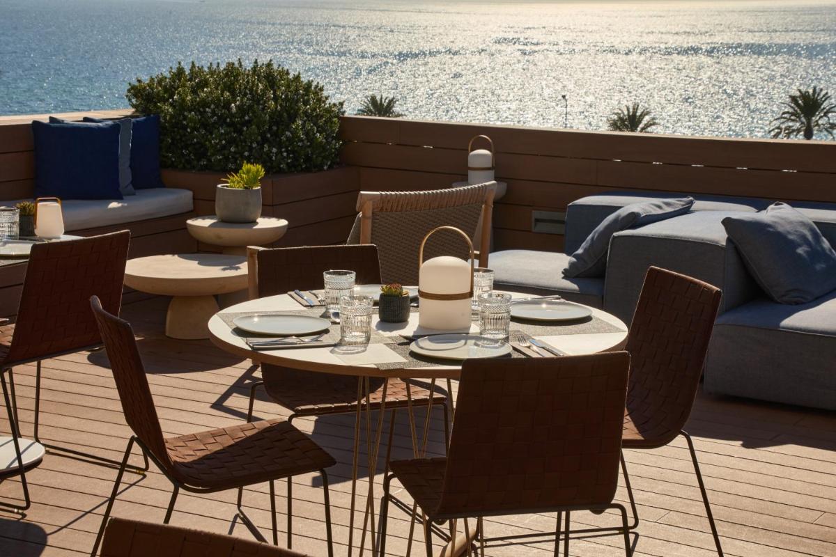 Un patio con mesa y sillas y el mar. en Hotel Calatrava, en Palma de Mallorca
