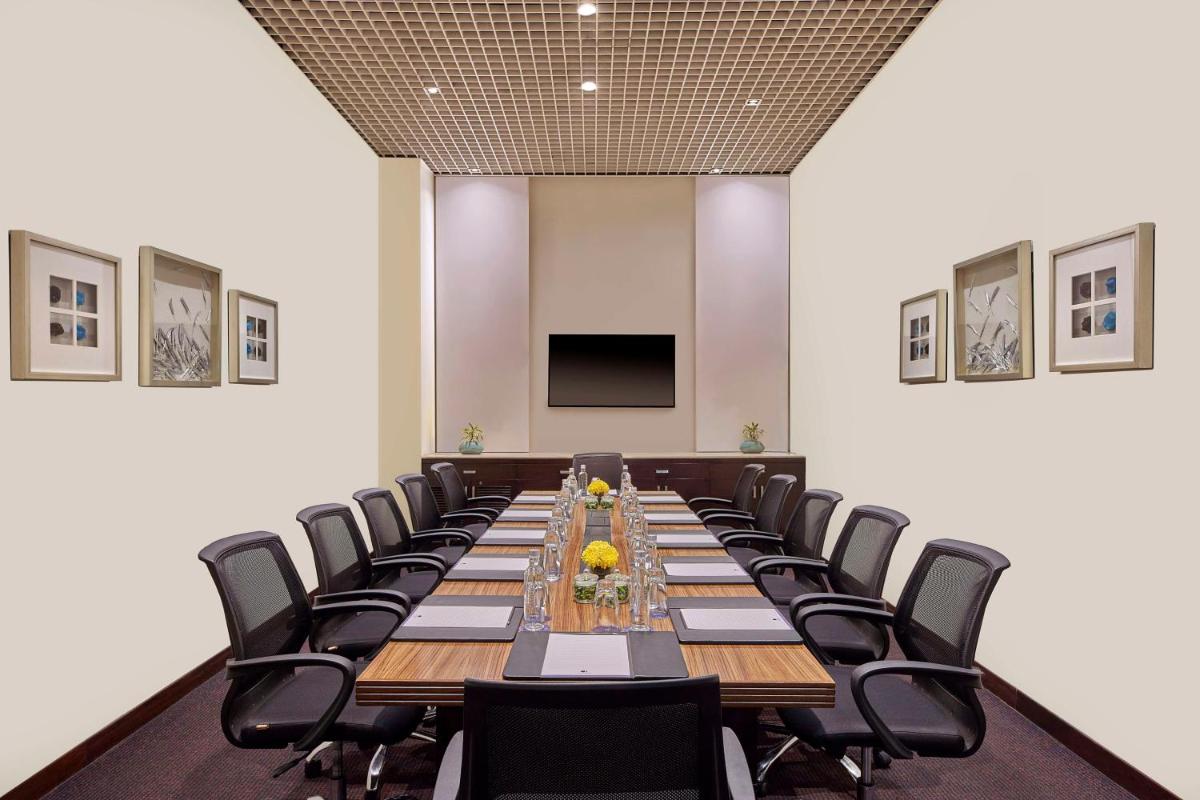 a large conference room with a long table and chairs at DoubleTree by Hilton Gurugram Baani Square in Gurgaon