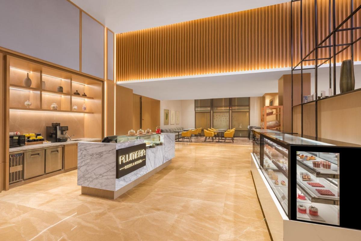 a large kitchen with a counter with yellow chairs at Fairfield by Marriott Dehradun in Dehradun