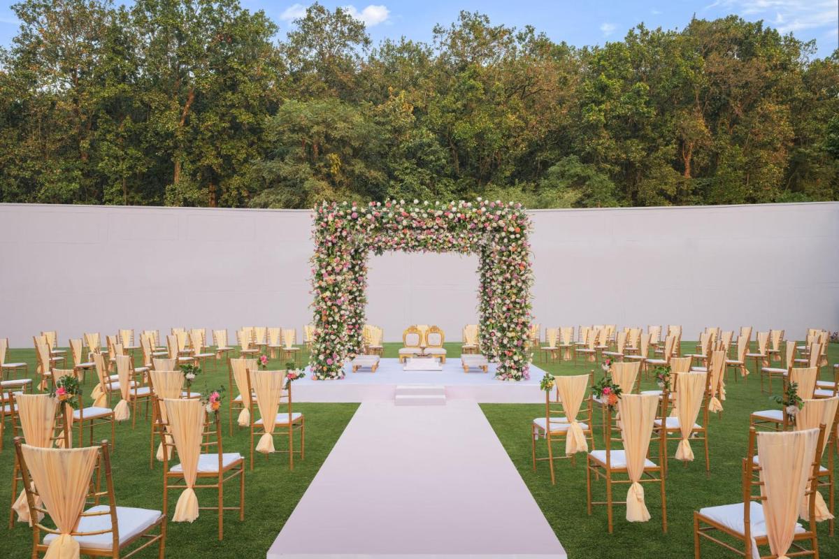 a wedding aisle with chairs and an arch with flowers at Fairfield by Marriott Dehradun in Dehradun