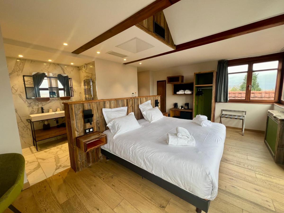 une chambre avec un grand lit avec des draps blancs dans l'établissement Hôtel La Garenne, à Saverne