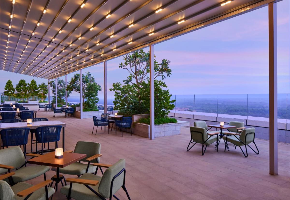 a restaurant with tables and chairs on a patio at Taj The Trees, Mumbai in Mumbai