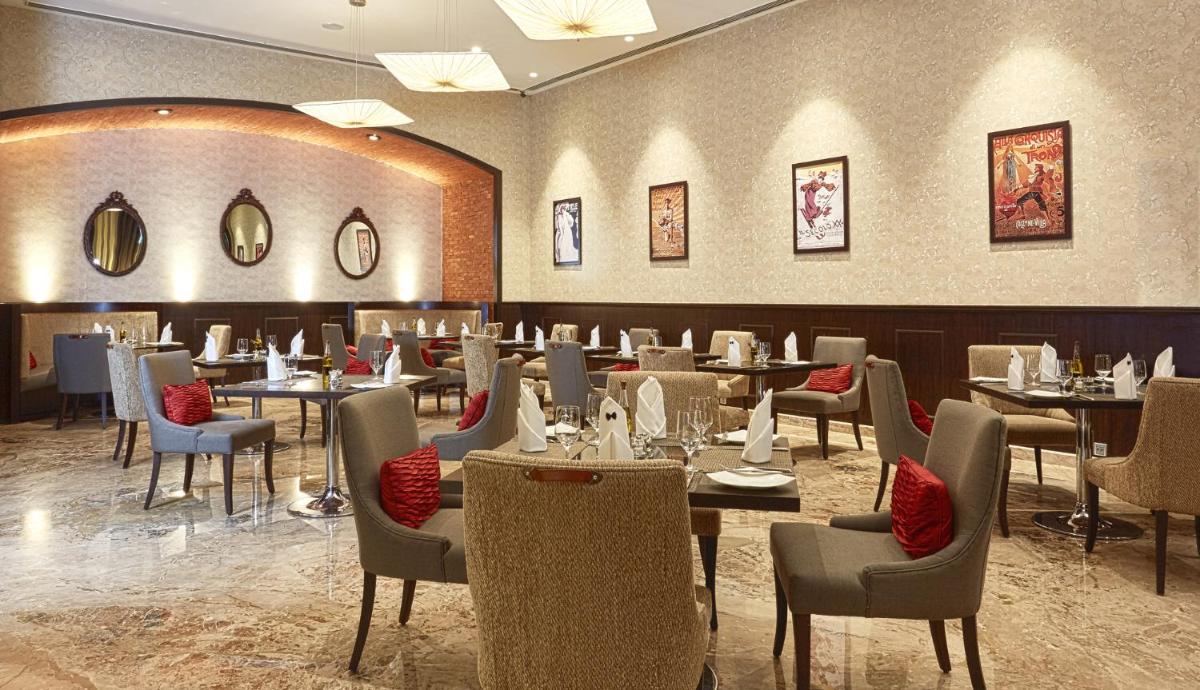 a restaurant with tables and chairs in a room at The Oterra in Bengaluru