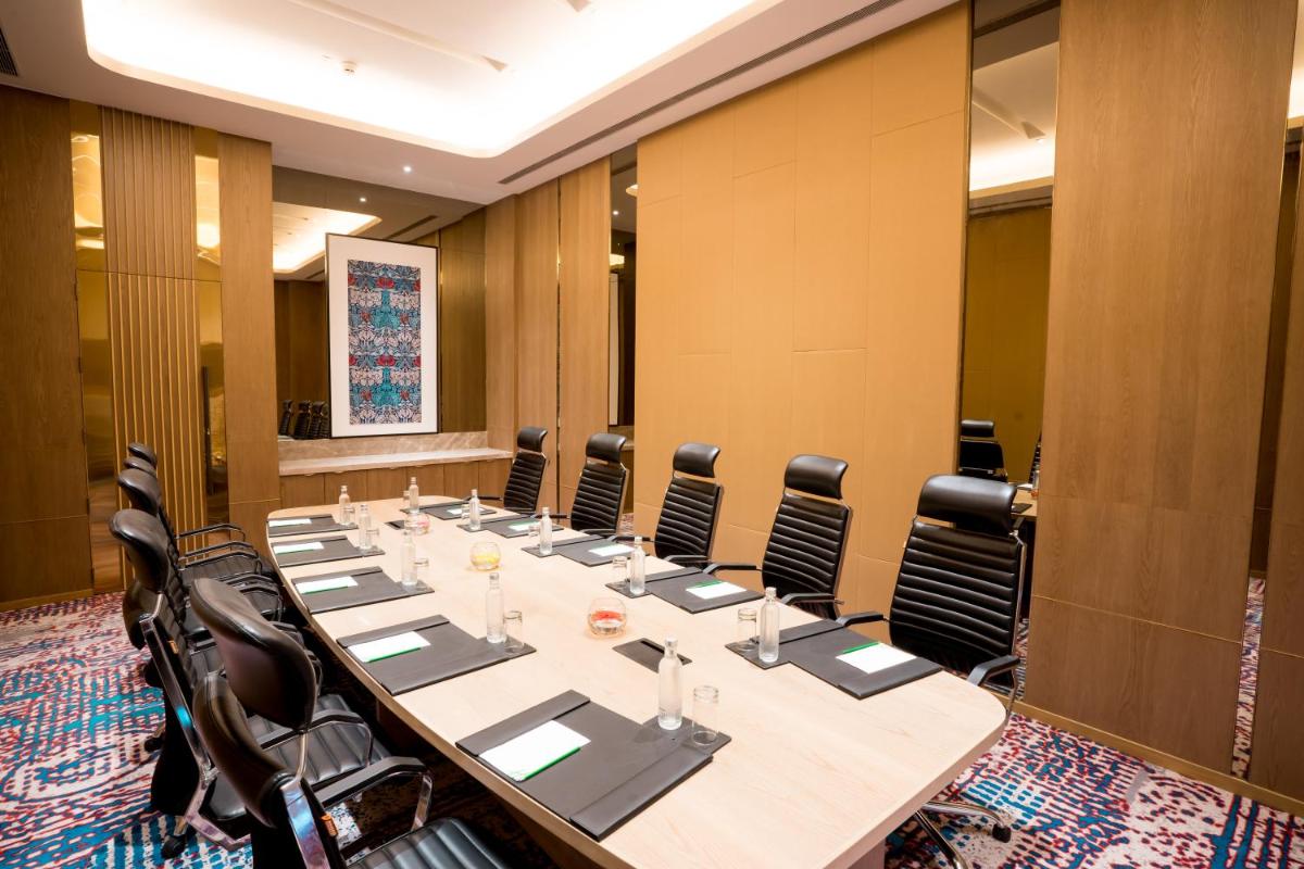 a large conference room with a long table and chairs at Holiday Inn Lucknow Airport by IHG in Lucknow