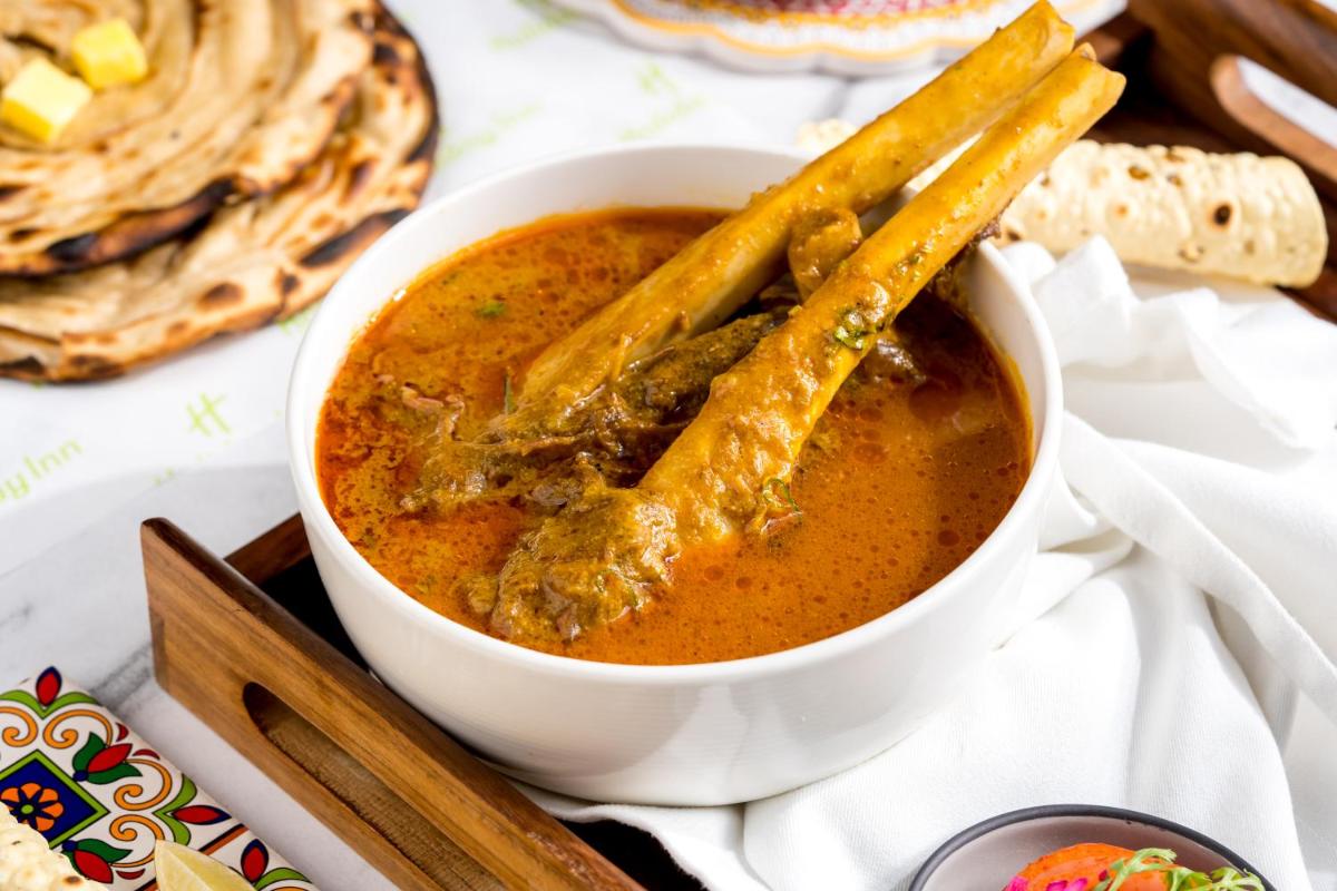 a bowl of soup with a pair of chopsticks in it at Holiday Inn Lucknow Airport by IHG in Lucknow