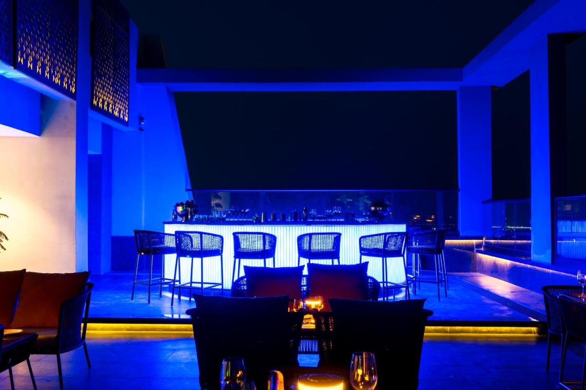 a bar in a restaurant with blue lighting at Holiday Inn Lucknow Airport by IHG in Lucknow