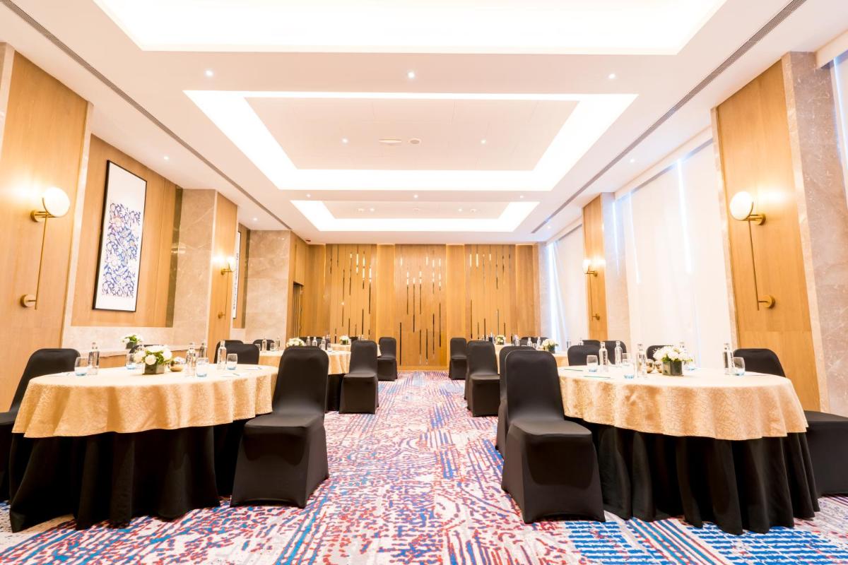 a conference room with tables and chairs in it at Holiday Inn Lucknow Airport by IHG in Lucknow