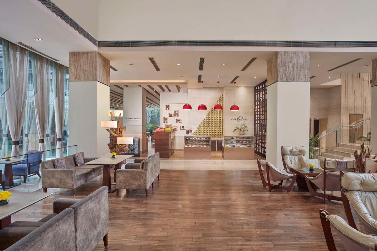 a lobby with couches and tables and chairs at DoubleTree by Hilton Gurugram Baani Square in Gurgaon