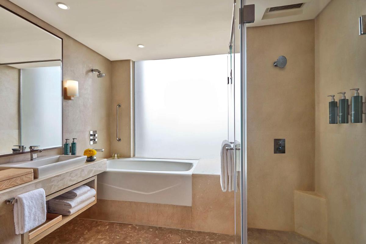 a bathroom with a tub and a sink and a shower at DoubleTree by Hilton Gurugram Baani Square in Gurgaon