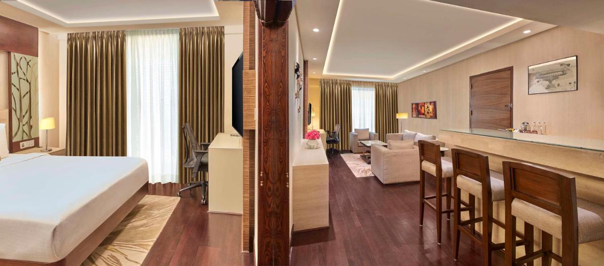 a hotel room with a bed and a living room at DoubleTree by Hilton Gurugram Baani Square in Gurgaon