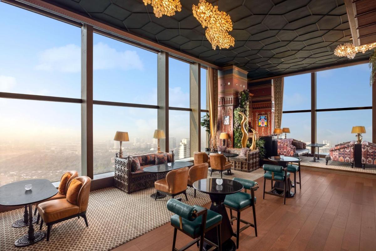 a room with large windows and tables and chairs at The St. Regis Mumbai in Mumbai
